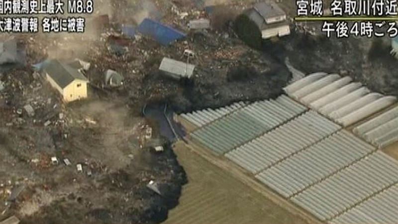 In this video image taken from Japan's NHK TV, a tsunami surge carrying debris sweeps between houses to reach poly tunnels on farmland near Sendai in Miyagi Prefecture Japan Friday March 11, 2011 following a massive earth quake. A magnitude 8.9 earthquake slammed Japan's northeastern coast Friday, unleashing a 13-foot (4-meter) tsunami that swept boats, cars, buildings and tons of debris miles inland. Fires triggered by the quake burned out of control up and down the coast. (AP PHOTO/NHK TV)