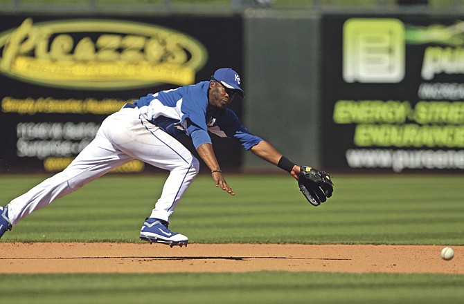 Kansas City Royals shortstop Irving Falu begins a fruitless dive-attempt on a single by Los Angeles Dodgers' Marcus Thames in the fourth inning of a spring training baseball game in Surprise, Ariz., Saturday, March 12, 2011.