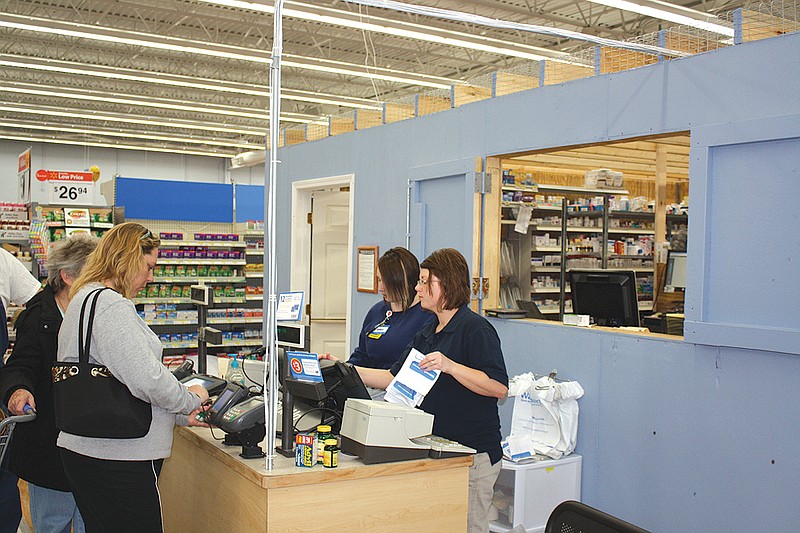 Mandi Steele/FULTON SUN photo: Walmart associates Amber Austin (left) and Nevada Wagaman help customers at the temporary pharmacy inside the Fulton Walmart on Friday. A temporary pharmacy had to be built as the other one is currently under construction.