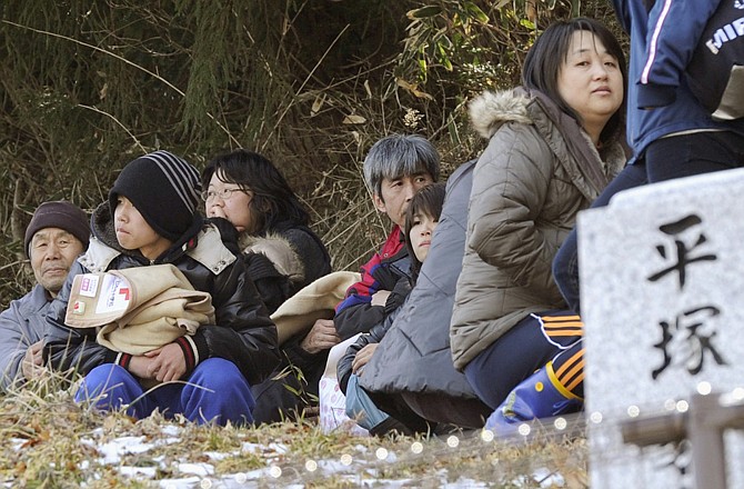 Residents take shelter on a higher ground in fear of another tsunami in Higashi Matsushima, Miyagi, northern Japan Monday, March 14, 2011 following Friday's massive earthquake and the ensuing tsunami. (AP Photo/Kyodo News)