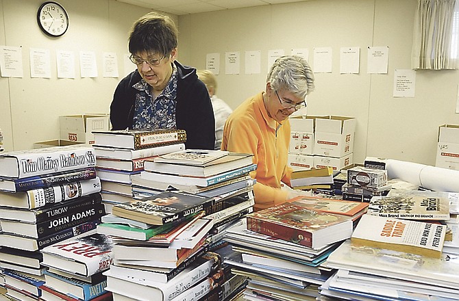 Volunteers Jan Baker, left, and Roberta Gumm help sort and box some of the thousands of books for the annual MRRL/ABLE Book Sale that starts Wednesday. 