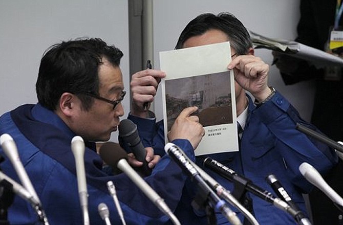 Tokyo Electric Co. employees in charge of public relations, in blue uniform, explain the situation of Fukushima Dai-ichi nuclear complex during a press conference Wednesday, March 16, 2011 in Tokyo, Japan. The outer housing of the containment vessel at the No. 4 unit at the Fukushima Dai-ichi nuclear complex erupted in flames early Wednesday, said a spokesman for the plant's operator, Tokyo Electric Power Co. (AP Photo/Eugene Hoshiko)