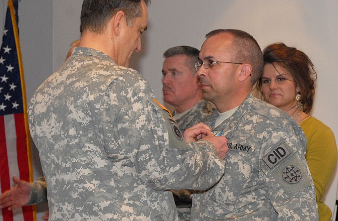 Maj. Gen. Stephen Danner, the Missouri National Guard adjutant general, pins Chief Warrant Officer 2 Leif Strand with the Joint Service Commendation Medal, 1st Oak Leaf Cluster award during a ceremony at the Ike Skelton Training Center on Thursday.