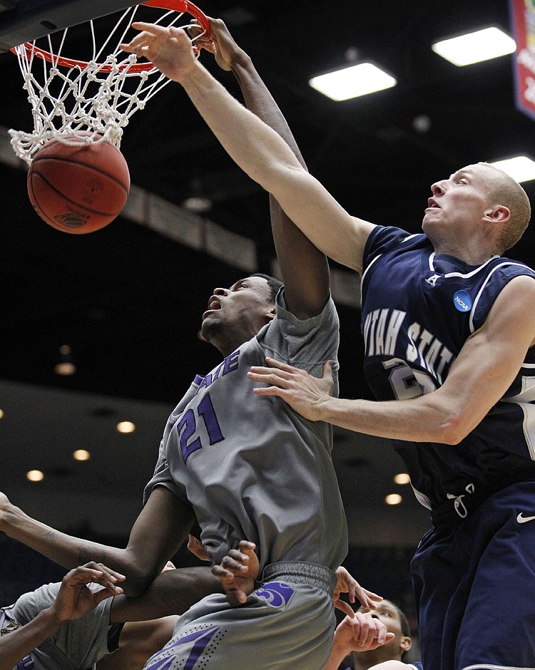 Kansas State's Jordan Henriquez-Roberts, left, scores as Utah State's Brady Jardine defends during a Southeast Regional NCAA college basketball tournament second round game Thursday, March 17, 2011, in Tucson, Ariz. 