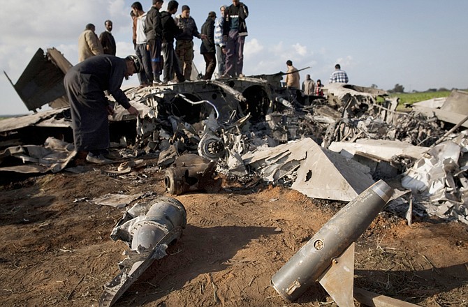 Libyans inspect the wreckage of a U.S. F-15E fighter jet after it crashed Tuesday in an open field in the village of Bu Mariem, eastern Libya, after both crew members ejected safely. 