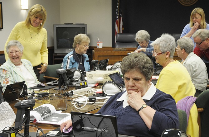 
Shirley Prenger, foreground right, is just one of the judges to learn the new electronic poll books at Cole County voting precincts. The new system automatically pulls up information by scanning the back of a driver's license. 