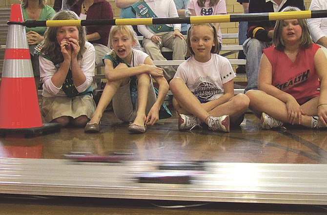 Four fourth-graders at St. Peter Elementary School's Girl Scout Troop 30739 watch a heat of four cars zip to the finish line in Sunday's first Powder Puff Pinewood Derby. The event is the same as a pinewood derby, except for Girl Scouts. Pictured from left are Emma Bonnot, Ashley Eskens, Kelsi Lennon and Sara Williams. 