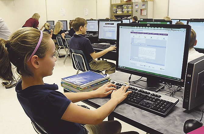 Kelsey Brester replies to an e-mail pal or e-pal through a school service at St. Joseph Cathedral School. The fifth-grader is able to enjoy the benefits of the work of dedicated parents and volunteers who worked to get current computer equipment for students. 