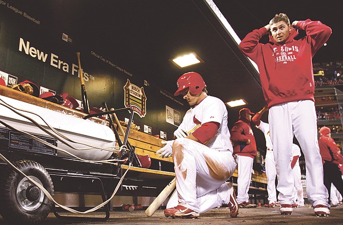 Ryan Theriot (left) of St. Louis warms up by a heater in the dugout as teammate Tyler Greene puts his hood up during the seventh inning of Monday night's game against the Pirates in St. Louis. 