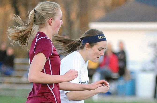 Helias' Courtney Lock (right) beats an Osage defender to the ball while scoring her second goal of Tuesday's game at the 179 Soccer Park.