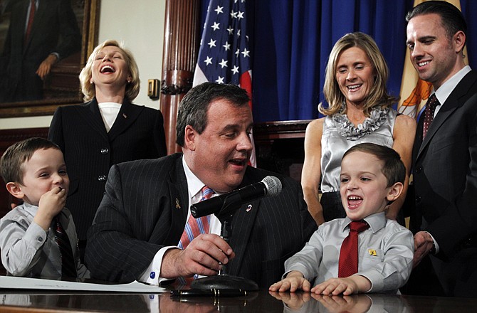 New Jersey Lt. Governor Kim Guadagno, left, Gov. Chris Christie, seated, and Dawn and Jon Koczon, right, laugh Wednesday in Trenton, N.J., at 5-year-old Jesse Koczon, right, as twin Brandon, left, looks on after Christie signed a proclamation making Jesse the state's honorary governor.