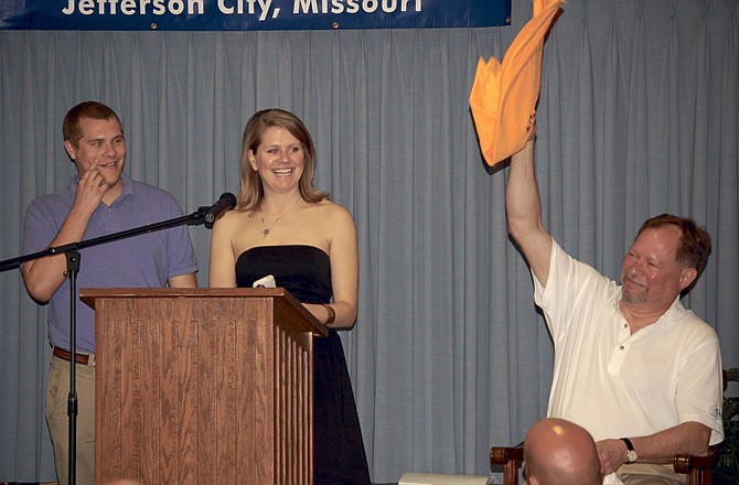 Jefferson City Mayor John Landwehr waves a flag of surrender as his children, Rebecca and David, tell embarrassing stories at a roast benefiting CASA on Saturday night at Immaculate Conception Church.