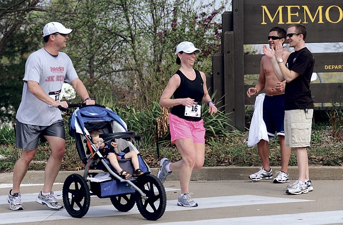 Robby Brown, right, and Rob Dusek congratulate Brian and Carrie Murray, and their 20-month-old son, Nolan, of Kansas City, as they near the finish Saturday during the second-annual Ava Brown Memorial 5K in Jefferson City. Robby Brown is Ava's father and Carrie Murrary is his wife, Sarah's, cousin. Ava Brown died of SIDS at 2 months old. 