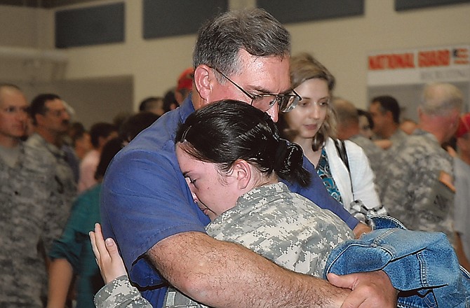 Pfc. Molly Tuley buries her head in dad Bruce Tuley's shoulder prior to boarding the bus for Fort Bliss, Texas. She is a PLS (palletized loading system) operator and will be joining the rest of the 548th Transportation Co. as they prepare for a year of duty in Afghanistan.