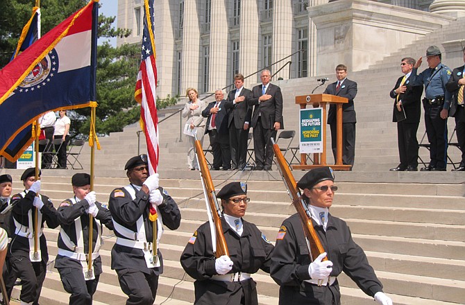 A color guard passes in front of a panel on hand Thursday to recognize National Crime Victims' Rights Week on the south lawn of the Capitol.