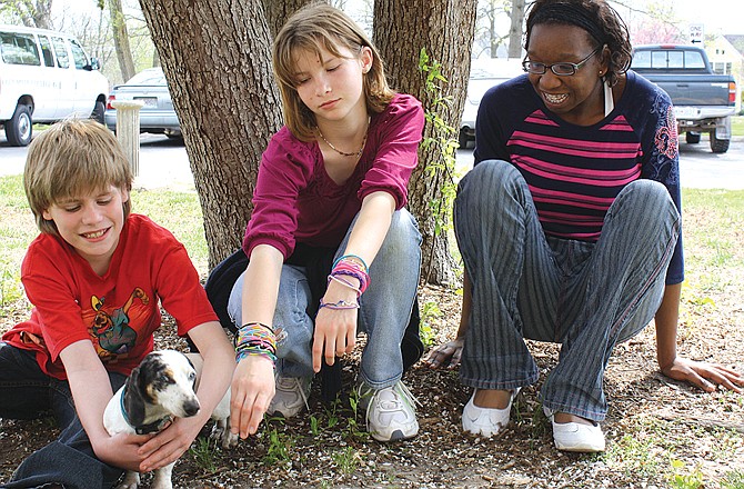 
Jessie Ergmann holds Sparky, as Cheyenne Dickerson lets the dog sniff her hand and Cherel Croom watches. The three Missouri School for the Deaf students are some of the many at the school who have bonded with the deaf dachshund.