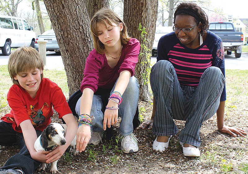 Jessie Ergmann holds Sparky as Cheyenne Dickerson lets the dog sniff her hand and Cherel Croom watches. These three Missouri School for the Deaf students are some of the many at the school who have bonded with the deaf dachshund.