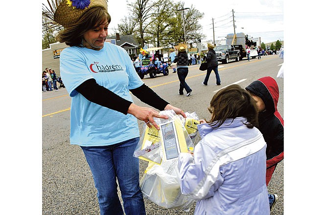 A member from Children's Learning Center hands out fliers and candy to parade-watchers Saturday at the Dogwood Festival Parade in Camdenton. 