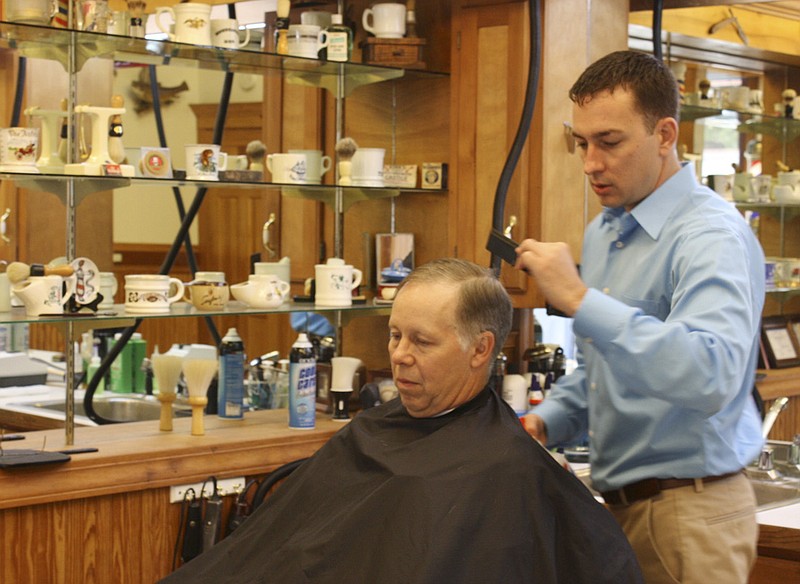 Brent Benn opened the Downtown Barber Shop Monday at 7 West 5th St. in downtown Fulton. "I have five years of experience as a barber and I always wanted to start my own business," Benn said. He has a collection of shaving mugs and mounted fish displayed in his new shop.