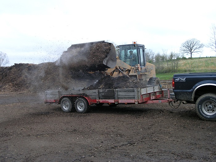 City Electric Employee Cody Kunze loads mulch into a resident's trailer at the Free Mulch Giveaway at the City Yard Waste Recycling Center Saturday, April 16.