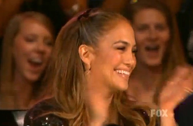 Jennifer Lopez at the judge's table reacts to singer Casey Abrams giving her a kiss to conclude his rendition of the Maroon 5 song, "Harder to Breathe," during the episode of American Idol that aired on Fox on Wednesday, April 20, 2011.