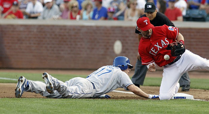 Texas Rangers first baseman Michael Young, front right, drops the ball allowing Kansas City Royals' Chris Getz (17) to get back to base in the top of the first inning during a baseball game at Rangers Ballpark in Arlington, Texas, Friday April 22, 2011.