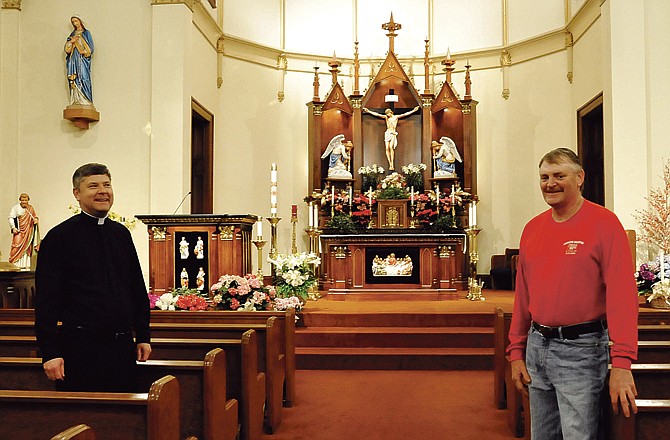 The altar pieces at St. Thomas The Apostle Church were done by Wayne Werdenhausen, right. Father Mark Porterfield is pictured at left. 