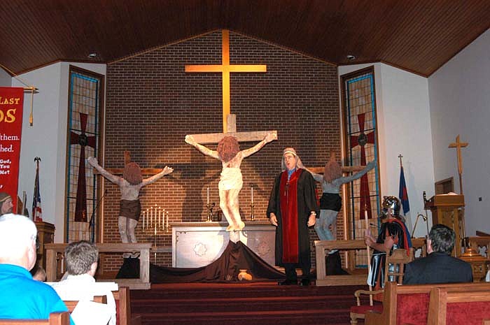 The High Priest (John Fahrni), center, speaks of the need for the death of one person to save the nation as a Roman Centurion (Dennis Farris) stands guard at the left. 