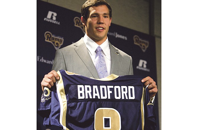 St. Louis Rams quarterback Sam Bradford holds up his new jersey after being drafted as last season's No. 1 overall pick. The Rams are in search of a receiver to compliment Bradford. 