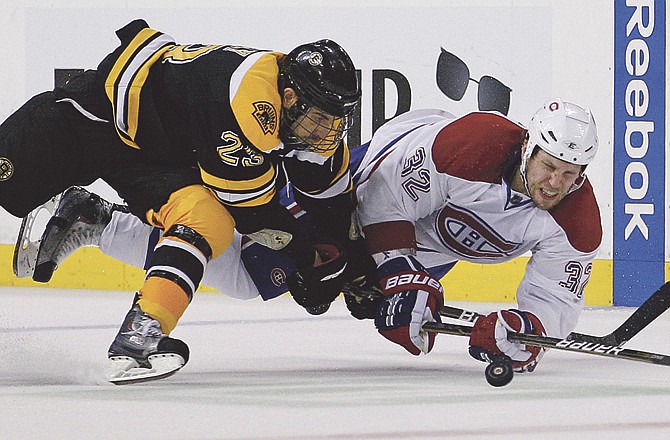 Boston Bruins center Chris Kelly (23) and Montreal Canadiens left wing Travis Moen (32) battle for the puck during the third period of Game 7 in a first-round NHL Stanley Cup hockey playoff series in Boston Wednesday, April 27, 2011. 