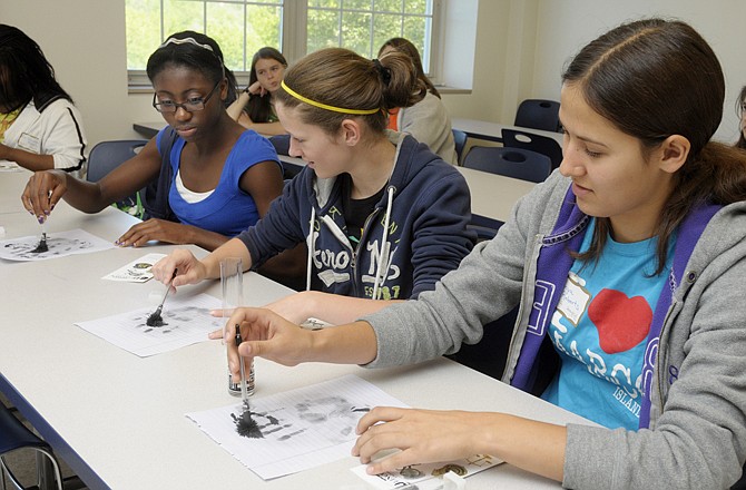 From right, Thomas Jefferson Middle School students Sonya Roberts, Caitlyn Mahoney and Louisa Nylander rub ash over their oily prints to create a visible outline. They participated Friday in the Lincoln University Sonia Kovalevsky Math for Girls Day on the school's campus. Middle and high school age girls attended the annual math day and were introduced to different uses for math than what they may normally encounter at school.