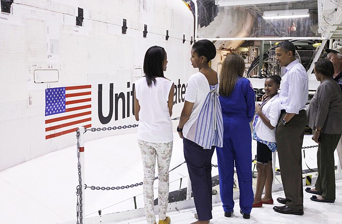 President Barack Obama, first lady Michelle Obama, daughters Sasha and Malia, and Astronaut Janet Kavandi look at the Space Shuttle Atlantis on Friday as they visit the Orbital Processing Facility at Kennedy Space Center in Cape Canaveral, Fla.