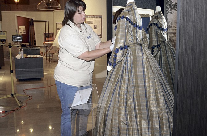 Missouri State Museum curator Julie Kemper creates a display of a silk day dress, made in a style from the 1860's and likely to be worn by a wealthy woman. The museum staff has been working on the last in a series of research projects on the Civil War in Missouri. 