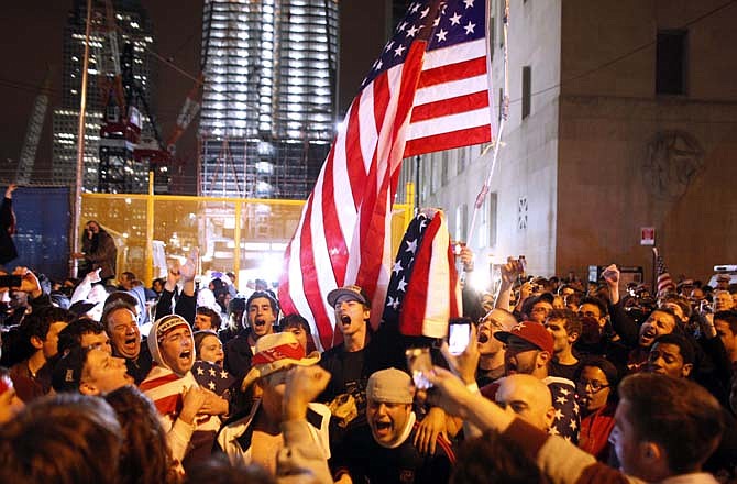 With the new One World Trade Center building in the background, second left, a large, jubilant crowd reacts to the news of Osama bin Laden's death at the corner of Church and Vesey Streets, adjacent to ground zero, during the early morning hours of Tuesday, May 2, 2011 in New York. 