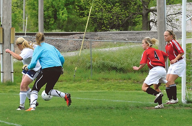 Kaitlyn Wideman (far left) of Helias delivers a backward kick that ends up getting past two Warrensburg defenders (right) for a goal during Monday's game at 179 Soccer Park.