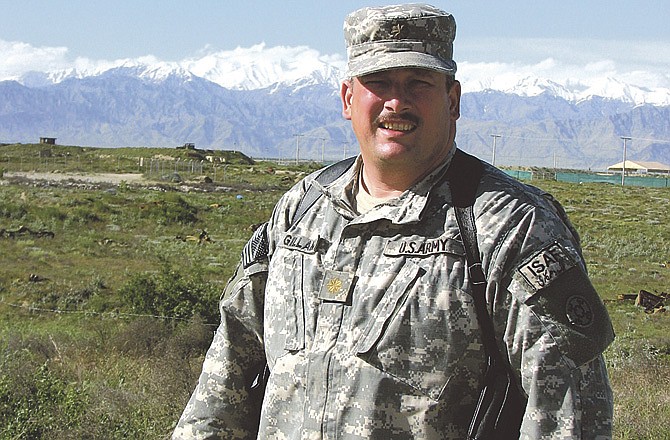 Maj. John Gillam poses in 2009 in front of the Hindu Kush mountain range in Bagram, Afghanistan. 