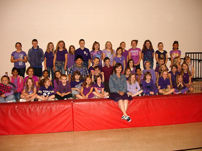 The Purple Dress Project Founder Ashley Hasty is surrounded by California Elementary School students wearing purple in support of her at the character assembly.