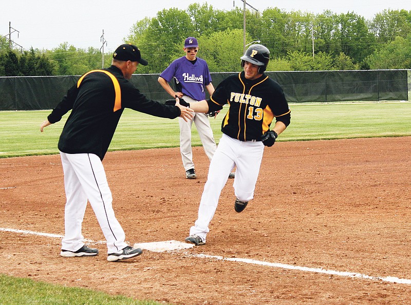 RYAN BOLAND/FULTON SUN photo: Fulton senior center fielder Ryan Fritz rounds third base and gets congratulations from Fulton head coach Darren Masek after a third inning grand slam in the Hornets 9-2 win over Hallsville in the quarterfinals of the Fulton Invitational Tournament on Monday.