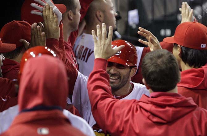 St. Louis Cardinals' Daniel Descalso celebrates in the dugout after hitting a three-run home run in the seventh inning of a baseball game against the Florida Marlins, Tuesday, May 3, 2011 in St. Louis.