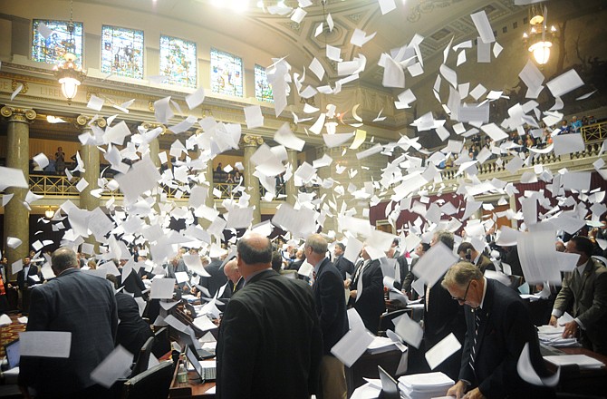 After flinging their working papers into the air, members of the Missouri House of Representatives watch them float down to the floor on May 13, 2011, as the regular session of the General Assembly adjourned.