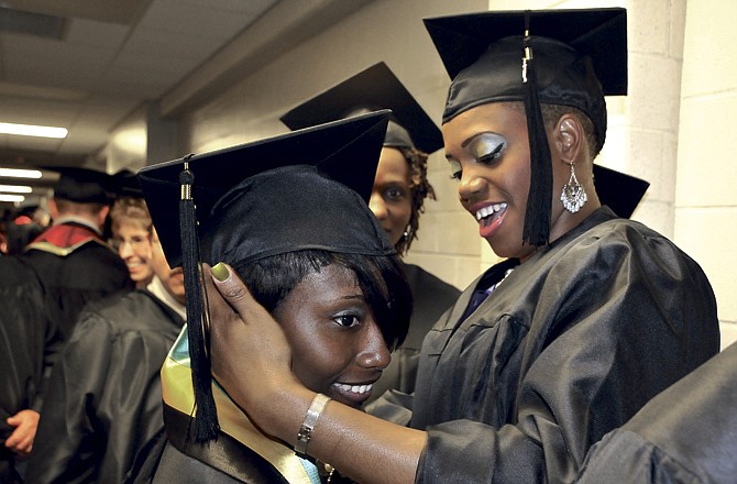 
Latory Brackett adjusts the cap of Kenesia Green before the start of the 2011 Spring graduation at Lincoln University in Jefferson City. 