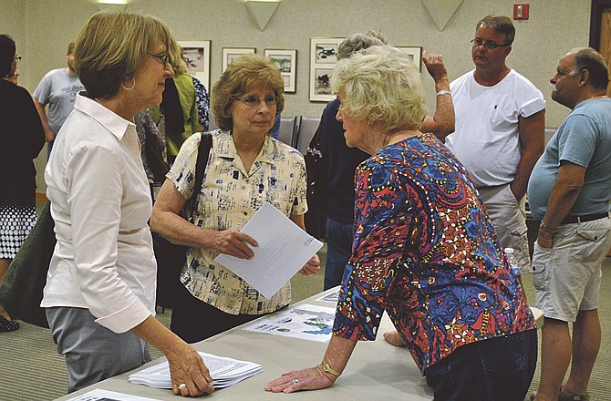 Cole County Partners for Clean Air Chairperson Felicia Poettgen, left, and a friend talk with Osage Beach Aldermen Lois Farmer about a possible smoking ban ordinance at a city public forum Thursday evening at Osage Beach City Hall. Osage Beach Aldermen Steve Kahrs, back in white shirt, chats with an Osage Beach resident and Lake Area Restaurateur Kym Ebling. 