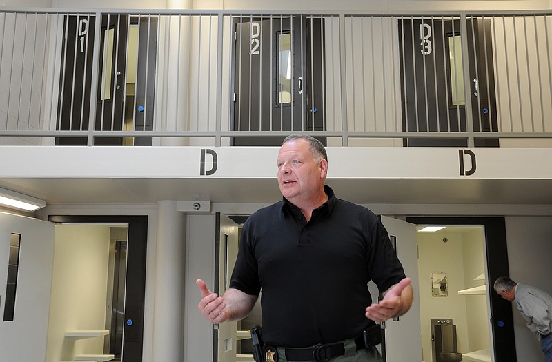 In this Tuesday, May 17, 2011 photo, Cole County Sheriff Greg White takes members of the media on a tour of the new county jail complex before its scheduled opening.