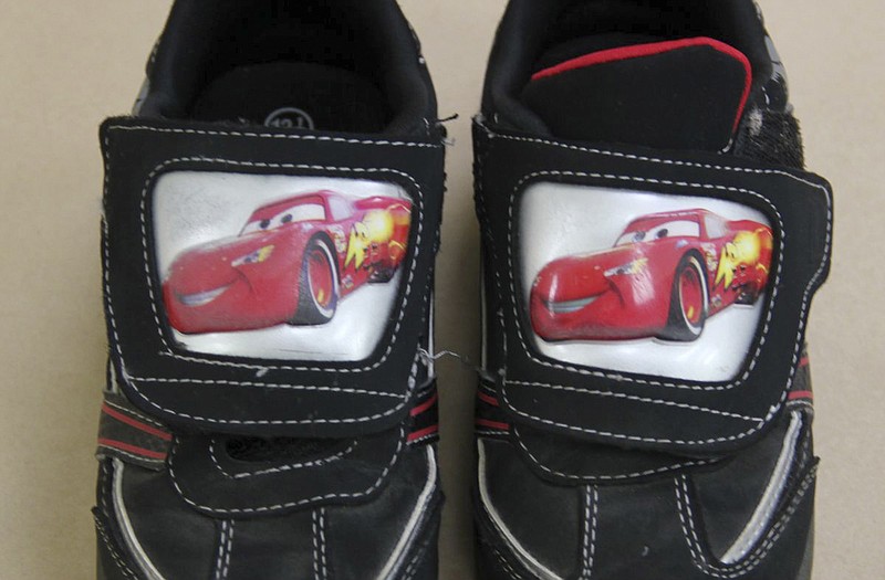 This photo released by the Maine State Police shows "Lightning McQueen" black sneakers worn by the young boy found dead along a remote road Saturday in South Berwick, Maine. Authorities are seeking help identifying the boy.