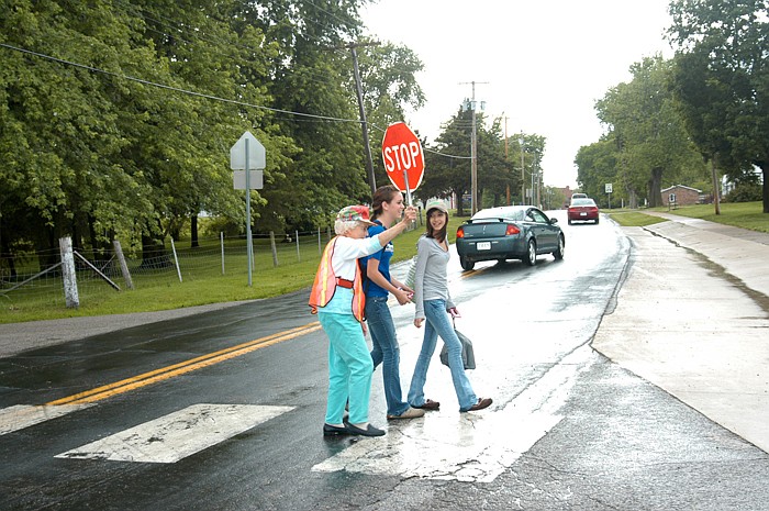 Jamestown School crossing guard Ethel Osborne escorts several students safely across Highway 179 on Wednesday, May 11, 2011. She is retiring after 23 years on the job.