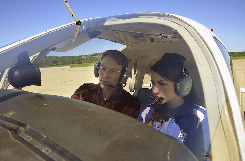 In this May 18, 2011 photo, Jessica Evans and flight instructor Bob Winkelman go over the controls of a Piper Warrior at the Jefferson City Flying Service at the Jefferson City Memorial Airport. 