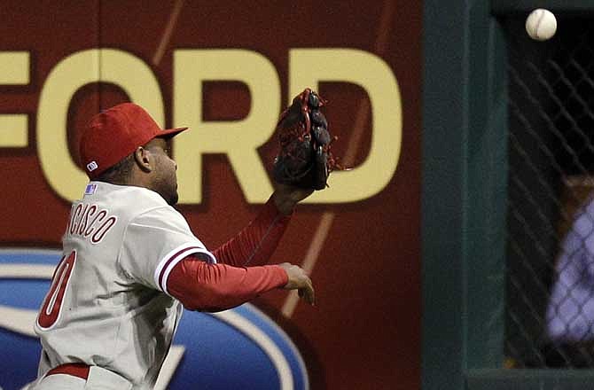 Philadelphia Phillies right fielder Ben Francisco cannot reach a ball hit for a ground-rule double by St. Louis Cardinals' Albert Pujols during the fifth inning of a baseball game Tuesday, May 17, 2011, in St. Louis. 