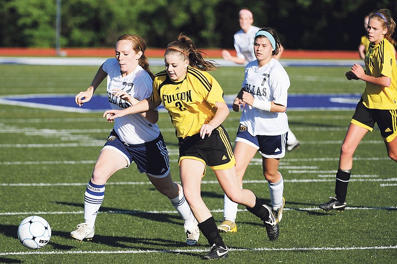 Fulton sophomore midfielder Rachelle Miller tries to beat Jefferson City Helias senior midfielder Arielle Chambers to a free ball during Tuesday night's Class 2, District 10 championship at Boonville High School's Gene Reagan Field. The top-seeded Lady Crusaders downed the No. 2 Lady Hornets 3-0.