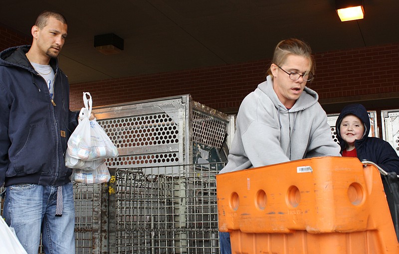 SERVE, Inc. volunteers pick up canned food collected by Fulton postal service letter carriers during the Natonal Association of Letter Carriers "Stamp Out Hunger" food drive on Saturday. SERVE volunteers sorting through the collected food are (from left) Lloyd Ryan, Jerry Friend and Carson Jones.