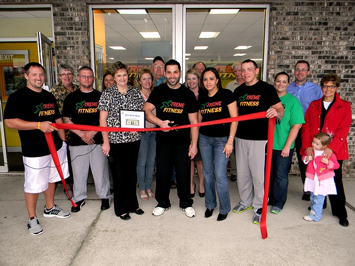 Members of the California Area Chamber of Commerce, family and friends help X-Treme Fitness Owner Krasi (Kris) Petrov cut the ribbon on his new business.